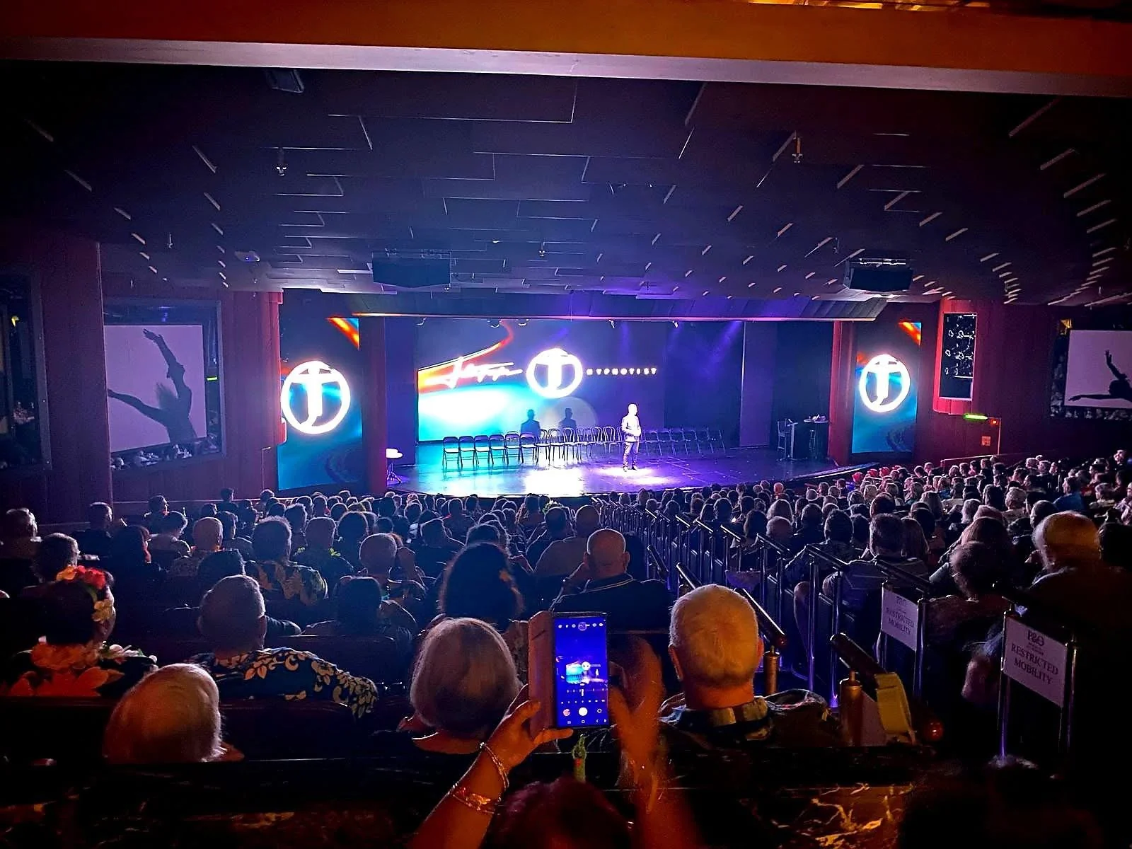 John Taylor performing with volunteers under blue and violet stage lights